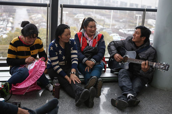 云南傈僳族的7位农民工坐在机场候机。